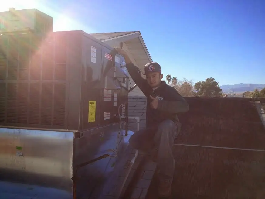 HVAC technician performing HVAC Inspection on a rooftop unit in Perry Heights